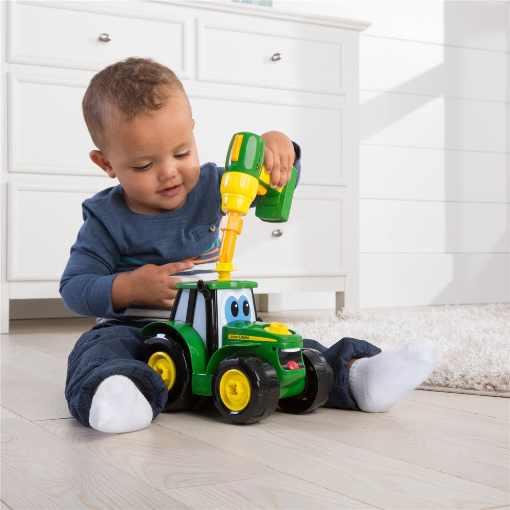 Child on floor playing with John Deere Build-A-Johnny Tractor Toy