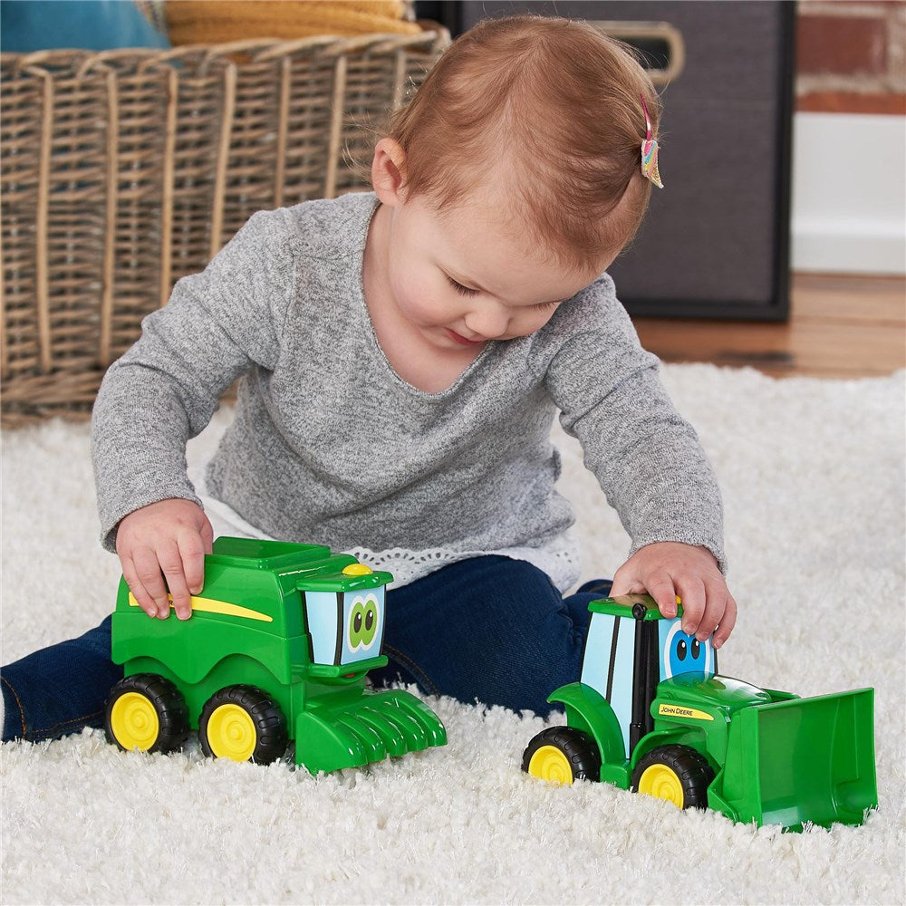 Child playing on floor rug with the 2 toys from John Deere Farmin' Friends